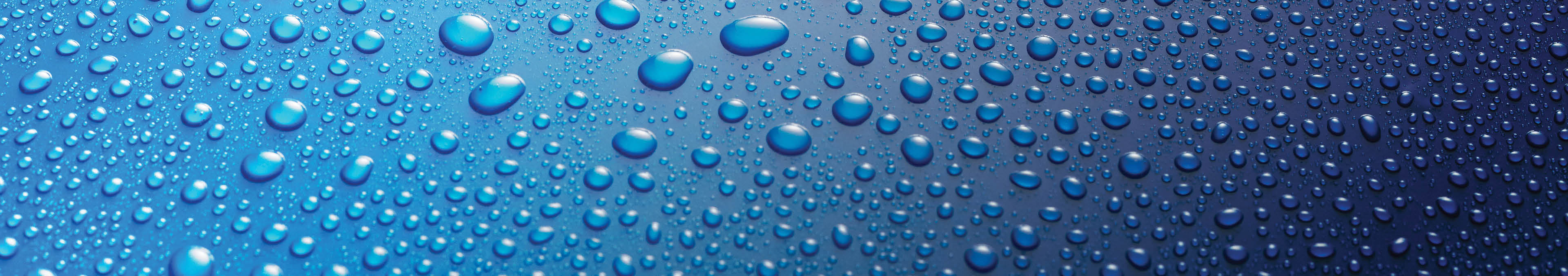 Panoramic banner of water drops from rain, dew or splashing on blue metal surface forming an abstract random background pattern