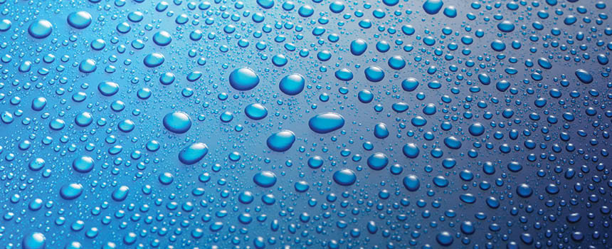 Panoramic banner of water drops from rain, dew or splashing on blue metal surface forming an abstract random background pattern